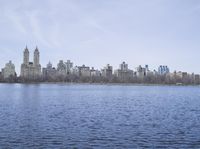 a view of the city from a distance from a lake in central park, new york