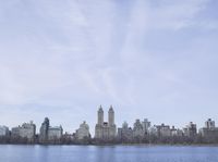 a view of the city from a distance from a lake in central park, new york