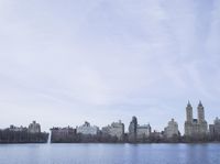 a view of the city from a distance from a lake in central park, new york