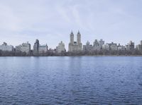 a view of the city from a distance from a lake in central park, new york