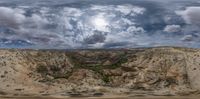 an artistic photo of a valley at sunset with the clouds overhead in a panoramic shot