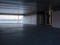 an empty space with windows that have large panes overlooking the city of london on the water