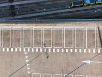 an aerial view of the inside of a parking lot and train tracks and tracks with cars on the street in a city