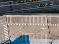 an aerial view of the inside of a parking lot and train tracks and tracks with cars on the street in a city