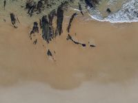 a lone surfer is waiting for the waves to arrive and go into shore as seen from above