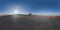 a photo taken from a fish eye lens of a race track, with the sun behind