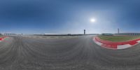 a reflection of a plane in the sky on a mirror lens view of a racing track