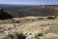 a view of a large valley at the top of some mountains with a distant area below