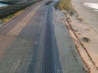 an aerial shot of the road to a beach with words written in it on a pavement