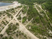 aerial view of large open country road between trees and sand dunes above river, near roadway in scenic rural area