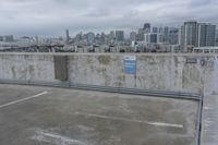 a car park with parking spaces and view of a city in the distance on a cloudy day