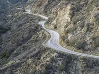 there is an aerial view of the scenic road going through the mountains and on the road are trees