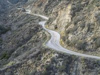 there is an aerial view of the scenic road going through the mountains and on the road are trees