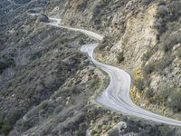 there is an aerial view of the scenic road going through the mountains and on the road are trees