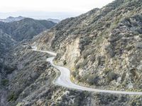 there is an aerial view of the scenic road going through the mountains and on the road are trees