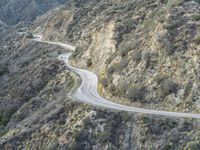 there is an aerial view of the scenic road going through the mountains and on the road are trees