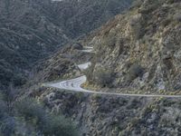 there is an aerial view of the scenic road going through the mountains and on the road are trees