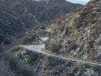 there is an aerial view of the scenic road going through the mountains and on the road are trees