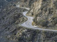 there is an aerial view of the scenic road going through the mountains and on the road are trees