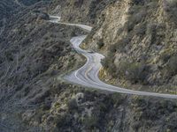 there is an aerial view of the scenic road going through the mountains and on the road are trees