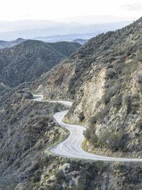 there is an aerial view of the scenic road going through the mountains and on the road are trees