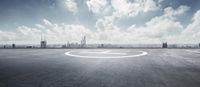 an empty paved air strip with a city in the background on a cloudy day at a plane landing