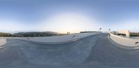 a skate park with the sun shining down on it's roof and ramps with a skateboard in front