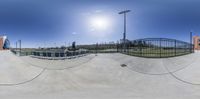 the view of a skate park in a fish eye lens like image of someone skateboarding