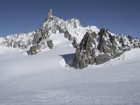 an aerial view of two skiers with mountain peaks in the background in wintertime