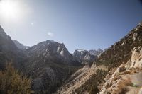 the mountains are covered with snow and sun light, and there is a trail going through them