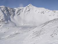 a view from a plane over a snow covered mountainside with two snow skiers on the snow