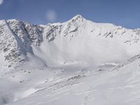 a view from a plane over a snow covered mountainside with two snow skiers on the snow