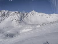 a view from a plane over a snow covered mountainside with two snow skiers on the snow