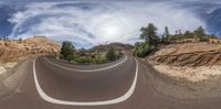 this is a fish - eye lens image of a curve road with a mountain in the distance