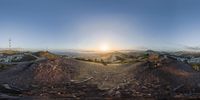 an aerial view of the sun shining on a hillside with a city in the distance