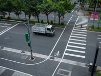 an overhead view of a street with multiple crosswalks and lots of trees surrounding the intersection