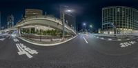 360 view of a busy city street at night from traffic lights across the road, with buildings along the street