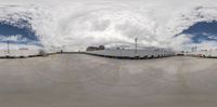 a wide lens view looking over a parking lot area and building with umbrellas on the windows