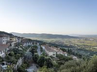 a long country road in front of a town with a view of a valley below