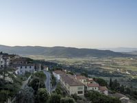 a long country road in front of a town with a view of a valley below