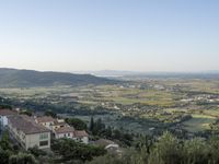 a long country road in front of a town with a view of a valley below