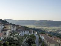 a long country road in front of a town with a view of a valley below