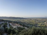 a long country road in front of a town with a view of a valley below