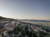 a long country road in front of a town with a view of a valley below