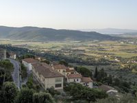 a long country road in front of a town with a view of a valley below