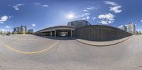 a fisheye lens picture of an empty parking lot on a sunny day with buildings