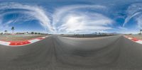 a photo of an empty race track with a sky background in the middle of it