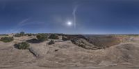 a view of the desert and sky with clouds and sunlight on it at the top