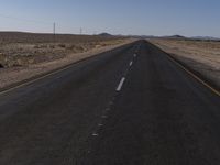 a road in the middle of a desert with a sign on both sides of it