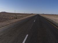 a road in the middle of a desert with a sign on both sides of it